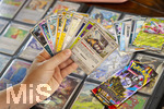 05.08.2026, Deutschland, Bayern, Pokemon-Sammelkarten, eine Teenagerin sammelt begeistert Pokemon-Karten in ihrem Sammelheft. 