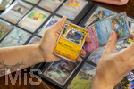 05.08.2026, Deutschland, Bayern, Pokemon-Sammelkarten, eine Teenagerin sammelt begeistert Pokemon-Karten in ihrem Sammelheft. 
