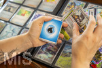 05.08.2026, Deutschland, Bayern, Pokemon-Sammelkarten, eine Teenagerin sammelt begeistert Pokemon-Karten in ihrem Sammelheft. 