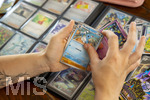 05.08.2026, Deutschland, Bayern, Pokemon-Sammelkarten, eine Teenagerin sammelt begeistert Pokemon-Karten in ihrem Sammelheft. 