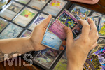 05.08.2026, Deutschland, Bayern, Pokemon-Sammelkarten, eine Teenagerin sammelt begeistert Pokemon-Karten in ihrem Sammelheft.   
