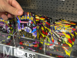 05.08.2026, Deutschland, Bayern, Pokemon-Sammelkarten im Regal eines Supermarktes in Bayern, ein junges Mädchen (Teenager) greift nach einem Päckchen.