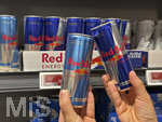 05.08.2026 Red Bull Getränke, im Supermarkt greift ein junges Mädchen (Teenager) nach Dosen, links Zuckerfrei und mit Zucker rechts.