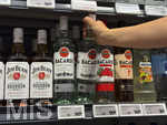 05.08.2026, Deutschland, Bayern, Spirituosen im Angebot der Getränkeabteilung eines Supermarktes in Bayern, ein junges Mädchen (Teenager) greift nach einer Bacardy-Rum-Flasche
