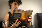 07.08.2026, Buchreihe von Rebecca Yarros, IRON FLAME, ein Teenager in Bad Wörishofen in Bayern sitzt auf ihrem Sofa und liest ihr Spannendes Buch. (Modelreleased) 