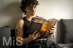 07.08.2026, Buchreihe von Rebecca Yarros, IRON FLAME, ein Teenager in Bad Wörishofen in Bayern sitzt auf ihrem Sofa und liest ihr Spannendes Buch. (Modelreleased) 