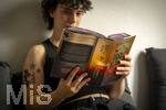 07.08.2026, Buchreihe von Rebecca Yarros, IRON FLAME, ein Teenager in Bad Wörishofen in Bayern sitzt auf ihrem Sofa und liest ihr Spannendes Buch. (Modelreleased) 