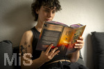 07.08.2026, Buchreihe von Rebecca Yarros, IRON FLAME, ein Teenager in Bad Wörishofen in Bayern sitzt auf ihrem Sofa und liest ihr Spannendes Buch. (Modelreleased) 