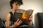 07.08.2026, Buchreihe von Rebecca Yarros, IRON FLAME, ein Teenager in Bad Wörishofen in Bayern sitzt auf ihrem Sofa und liest ihr Spannendes Buch. (Modelreleased) 