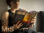 07.08.2026, Buchreihe von Rebecca Yarros, IRON FLAME, ein Teenager in Bad Wörishofen in Bayern sitzt auf ihrem Sofa und liest ihr Spannendes Buch. (Modelreleased) 