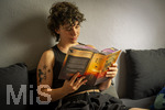 07.08.2026, Buchreihe von Rebecca Yarros, IRON FLAME, ein Teenager in Bad Wörishofen in Bayern sitzt auf ihrem Sofa und liest ihr Spannendes Buch. (Modelreleased) 