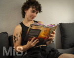 07.08.2026, Buchreihe von Rebecca Yarros, IRON FLAME, ein Teenager in Bad Wörishofen in Bayern sitzt auf ihrem Sofa und liest ihr Spannendes Buch. (Modelreleased) 