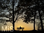 11.08.2026, Bad Wörishofen im Unterallgäu, Sonnenuntergangsstimmung am Ostpark, eine Frau geniesst die Aussicht von einer Bank am Ortsrand der Kneippstadt. Am Mittwoch ist Sonnenfinsternis (12.08.2026), da ist dieser Punkt optimal für die Beobachtung des Himmelsereignisses.