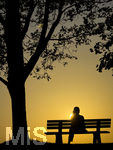 11.08.2026, Bad Wörishofen im Unterallgäu, Sonnenuntergangsstimmung am Ostpark, eine Frau geniesst die Aussicht von einer Bank am Ortsrand der Kneippstadt. Am Mittwoch ist Sonnenfinsternis (12.08.2026), da ist dieser Punkt optimal für die Beobachtung des Himmelsereignisses.