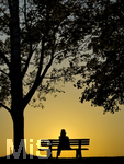 11.08.2026, Bad Wörishofen im Unterallgäu, Sonnenuntergangsstimmung am Ostpark, eine Frau geniesst die Aussicht von einer Bank am Ortsrand der Kneippstadt. Am Mittwoch ist Sonnenfinsternis (12.08.2026), da ist dieser Punkt optimal für die Beobachtung des Himmelsereignisses.