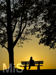 11.08.2026, Bad Wörishofen im Unterallgäu, Sonnenuntergangsstimmung am Ostpark, eine Frau geniesst die Aussicht von einer Bank am Ortsrand der Kneippstadt. Am Mittwoch ist Sonnenfinsternis (12.08.2026), da ist dieser Punkt optimal für die Beobachtung des Himmelsereignisses.