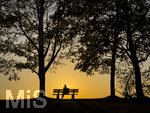 11.08.2026, Bad Wörishofen im Unterallgäu, Sonnenuntergangsstimmung am Ostpark, eine Frau geniesst die Aussicht von einer Bank am Ortsrand der Kneippstadt. Am Mittwoch ist Sonnenfinsternis (12.08.2026), da ist dieser Punkt optimal für die Beobachtung des Himmelsereignisses.