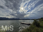 20.08.2026, am Hopfensee bei Füssen im Allgäu, Ein Steg im See, die Sonne kämpft sich durch die Wolken, hinten zieht ein Gewitter auf wo der Regen bereits aus den Wolken fällt.