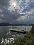 20.08.2026, am Hopfensee bei Füssen im Allgäu, Ein Steg im See, die Sonne kämpft sich durch die Wolken, hinten zieht ein Gewitter auf wo der Regen bereits aus den Wolken fällt.