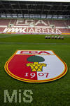 30.08.2026, Fussball Bundesliga 2026/2027, 1.Spieltag, FC Augsburg - FC Schalke 04, in der WWK-Arena Augsburg, FCA-Vereinswappen liegt als Teppich vor dem Spielfeld aus. 