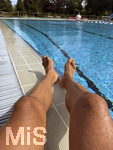 04.09.2026, Freibad Bad Wörishofen (Bayern), ein Mann sitzt am Schwimmbecken und lässt seine Beine bräunen.  (Model Release vorhanden)   