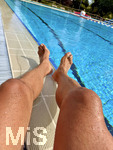 04.09.2026, Freibad Bad Wörishofen (Bayern), ein Mann sitzt am Schwimmbecken und lässt seine Beine bräunen.  (Model Release vorhanden)   