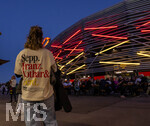 27.09.2026, Fussball UEFA Nations-League 2026/2027, 2.Spieltag, Deutschland - Griechenland, in der WWK-Arena Augsburg, Stadionfassade mit Rot-Gelben Farben der Neonbeleuchtung. Zuschauerin steht davor, auf dem Shirt steht Sepp, Franz, Lothar und Gerd. 