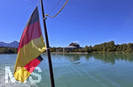 15.09.2026, Forggensee bei Füssen im Allgäu, das Festspielhaus Füssen, Aussenaufnahme mit Blick vom See. Im Vordergrund eine Deutschlandfahne die am Dampfer-Heck des Ausflugsschiffes MS-Allgäu angebracht ist.