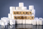 14.10.2026, Thema Zuckersteuer für Softgetränke. Studioaufnahme mit Würfelzucker und Schriftzug ZUCKERSTEUER.  Die Bundesregierung hat sich im Streit um die Zuckersteuer für Getränke geeinigt, Der Kompromiss sieht eine zweistufige Steuer und Ausnahmen für kleinere Hersteller vor. So soll ab dem 1. Juli 2027 ein Steuersatz von 26 Cent auf gesüßte Getränke mit einem Zuckergehalt ab 5 Gramm pro 100 Milliliter erhoben werden. Bei einem Zuckergehalt von 8 Gramm pro 100 Milliliter soll der Satz 32 Cent betragen.